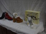 three pairs of shoes sitting on a table with a box