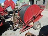 une photo d'une machine rouge à laquelle est fixée une grande bobine à l'arrière