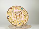 une assiette ornée d'un motif doré et rose
