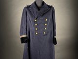 a blue coat with gold buttons on a mannequin stand