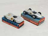 two toy cars sitting on top of a box on top of a white surface