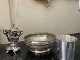un bol en argent et une coupe en argent posés sur une table