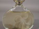 a small glass bottle with a white flower inside of it