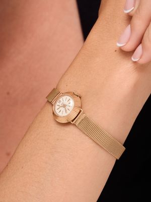 a woman wearing a gold watch on her wrist with a black background