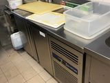 plan de travail en acier inoxydable dans une cuisine professionnelle, équipé d'un évier et d'un lave-vaisselle
