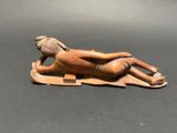 statue of a woman laying on a blanket on a black surface