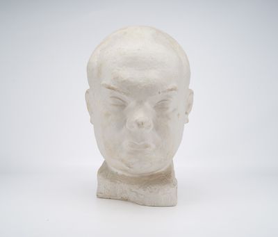 a white sculpture of a man ' s head on a white surface