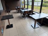 tables and chairs in a restaurant with a view of a field
