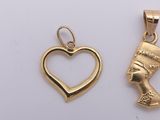 two gold pendants with a heart and an egyptian head in the middle