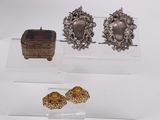 deux paires de boucles d'oreilles en argent et un écrin posés sur une surface blanche