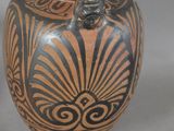 a vase with a black and brown design on it