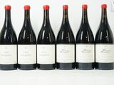six bouteilles de vin sont alignées sur une table