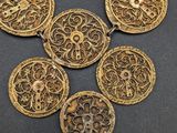 a close up of a gold necklace with four medallions on it