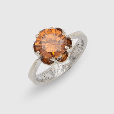 un gros plan d'une bague sertie d'un diamant brun