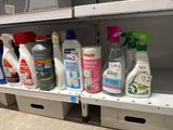 many bottles of cleaning products on a shelf in a store
