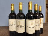 four bottles of wine are lined up on a table