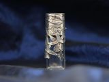 a glass bottle that has a silver design on it