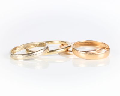 two gold wedding rings on a white background