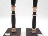pair of black and gold candlesticks on wooden bases