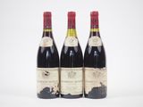 trois bouteilles de vin rouge sont posées côte à côte sur une surface blanche