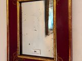 a mirror hanging on the wall with a red frame