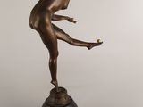an image of a bronze statue of a woman holding a tennis racquet