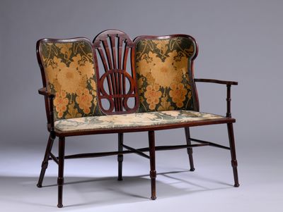 un banc en bois dont l'assise est recouverte d'un tissu à motifs floraux