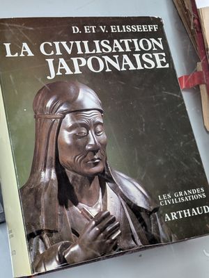 un livre surmonté d'une statue représentant une femme