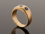 a close up of a gold ring with a blue stone in the middle