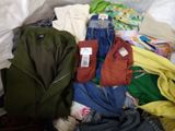 a pile of clothes that is sitting on a bed