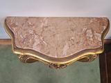 a marble top table with a gold frame on it