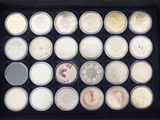 many different types of coins in a display case