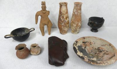 several pieces of pottery sitting on a white surface next to other items