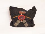 a black bag with a red button on it