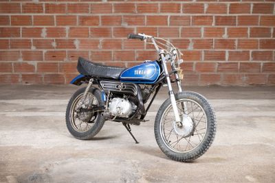 a blue motorcycle parked in front of a brick wall