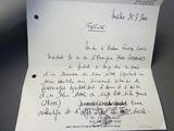 une lettre manuscrite sur une feuille de papier posée sur une table