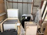 un tas de vieux appareils électroménagers et de cartons dans un local de stockage