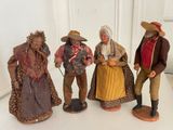 three figurines of people dressed in colonial clothing are posed on a white surface
