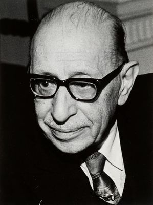 photographie en noir et blanc d'un homme portant des lunettes et un costume
