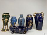 five vases and a bowl sitting on a table