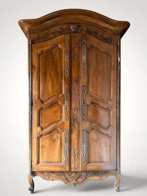 an image of a wooden armoire with carvings on the doors