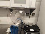 a microwave and a fan on the counter in the kitchen
