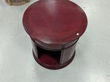 une petite table au plateau rouge et une chaise à l'arrière-plan