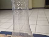 a glass bottle that has a small amount of water in it