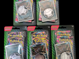 quatre paquets de cartes à collectionner Pokémon dans des sachets en plastique, sur fond noir