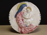 une assiette sur laquelle est représentée une femme tenant un bébé dans ses bras