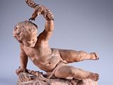 statue of a boy on a rock with a bird on his shoulder