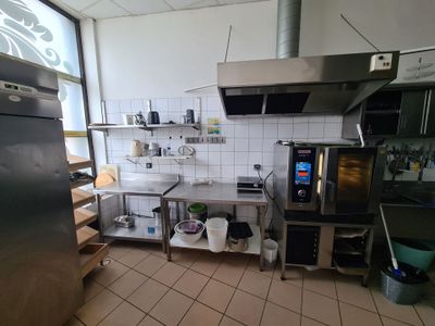 a kitchen with a refrigerator, stove, sink, and other appliances