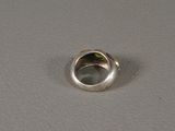 a silver ring with a green leaf inside of it