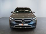 the front of a silver mercedes suv parked in a showroom